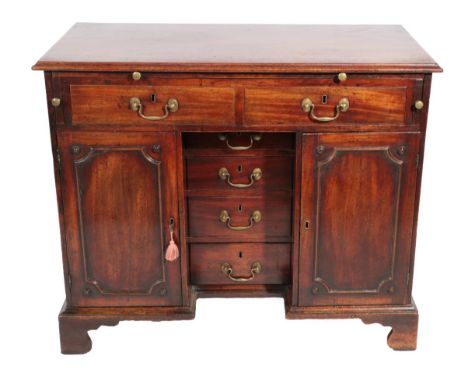 A George III Mahogany Kneehole Desk, circa 1760, the moulded top with a pull-out slide above two frieze drawers, the base wit