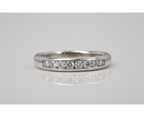 An 18ct white gold and diamond half eternity ring, channel set with eight brilliant cut diamonds, total 0.36cts, ring size O.