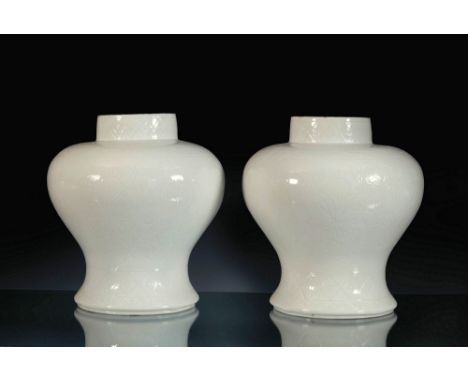 A pair of Chinese white glazed soft paste porcelain vases, possibly Qing Dynasty, 18th century, the very short, circular foot