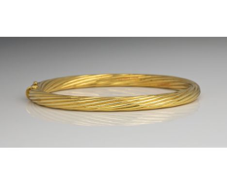 An 18ct yellow gold bangle, with spiral reeded decoration, 5.7 x 5.1cm. internal diameter.