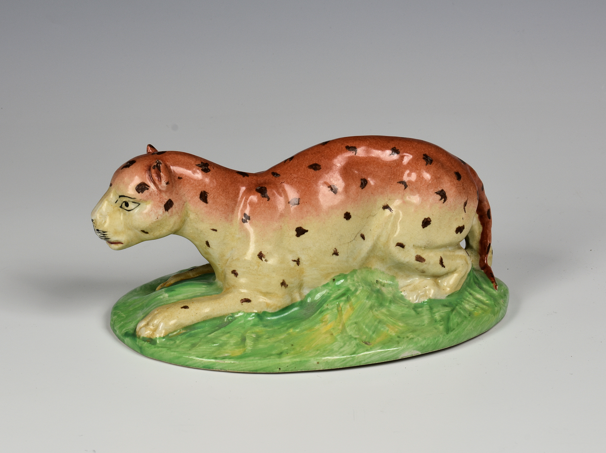 A Staffordshire pottery model of a crouching leopard, 19th century, on ...