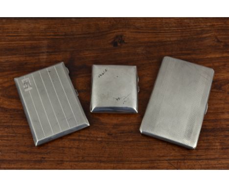 Three silver cigarette cases, the first by Roberts and Dore, Birmingham, 1945, of rectangular form with rounded corners, engi