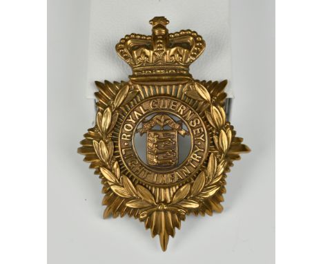 A Royal Guernsey Light Infantry brass helmet plate, bearing crown, laurel and insignia.