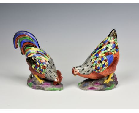 A pair of Continental porcelain figures of a cockerel and hen, early 20th century, with polychrome and gilt painted plumage, 