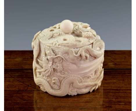 A Japanese carved ivory pot and cover, Meiji period (1868-1912), the circular box heavily carved throughout with dragons amid