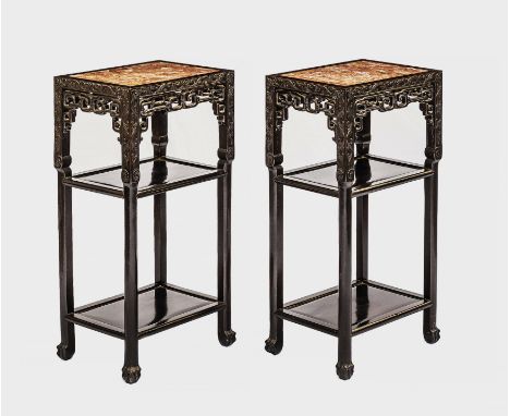 A pair of Chinese carved and ebonised hardwood stands with inset marble tops, 19th century, the rectangular tops over foliate