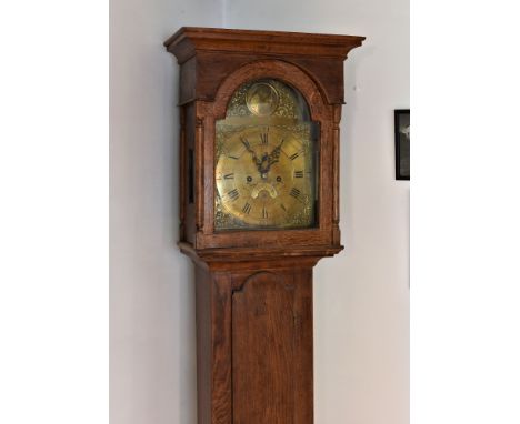 A rare 18th century oak Channel Islands longcase clock, the case with flared cavetto pediment over an arched glazed door flan