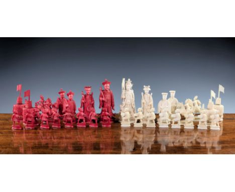 A Chinese Canton carved ivory chess set, late 19th / early 20th century, stained red and natural, carved as the Imperial fami