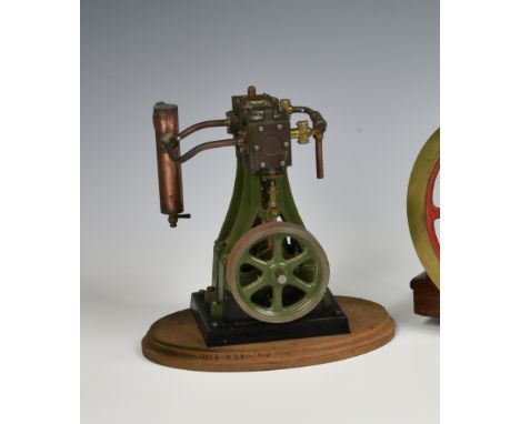 A well engineered stationary vertical twin cylinder live steam engine, single spoked flywheel to side, painted khaki green, s