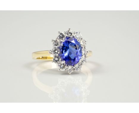 An 18ct yellow gold, Tanzanite and diamond cluster ring, the oval cut 2.72ct Tanzanite within a border of twelve brilliant cu