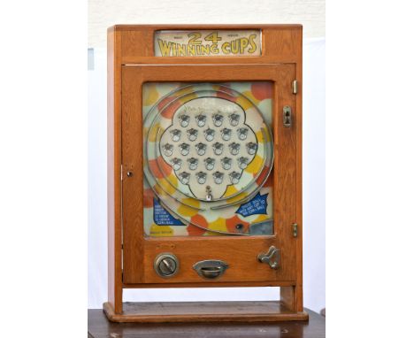 Arcade - a mid-20th century '24 Winning Cups' bagatelle type penny slot machine, the wall hanging machine with upper display 