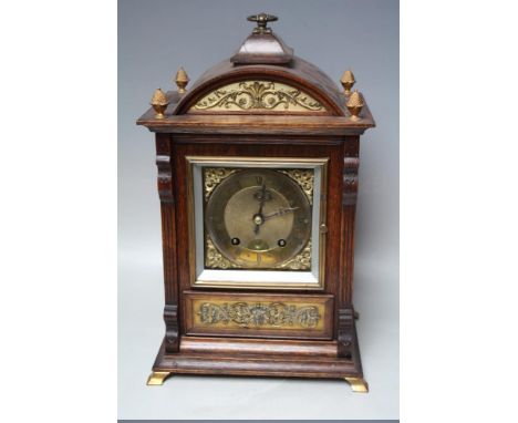 AN EARLY 20TH CENTURY OAK CASED MANTEL CLOCK BY LENZKIRCH, the architectural case with decorative gilt metal foliate panels, 