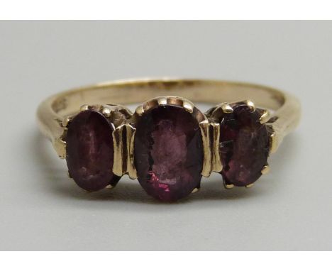 A 9ct gold, three stone almandine garnet ring, 2.1g, K 