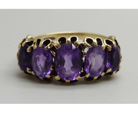 A 9ct yellow gold and amethyst ring, 4.5g, R, (set with one 8x6mm, two 7x6mm and two 6x5mm oval cut amethysts) 