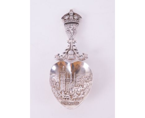 An Edwardian silver caddy spoon with the Arms of Scotland, The Royal Crown and a Thistle on the stem and a view of Balmoral C