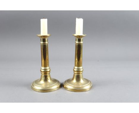 A pair of late Georgian brass candlesticks, on circular bases, 7" high (ex Robin Bellamy Antiques), an early Georgian brass c