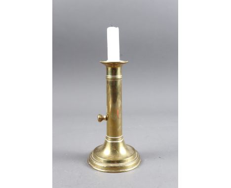 An antique brass ejector candlestick, on circular foot, 6 3/4" high (ex Wyndham Antiques)