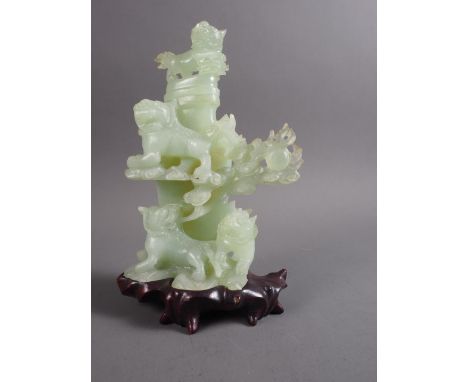 A Chinese carved jade vase and cover modelled as  four Dogs of Fo amongst clouds, on fitted hardwood stand, 9 1/4" high overa