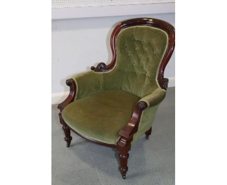 A 19th century mahogany showframe armchair, button upholstered in a green velvet, on turned and castored supports