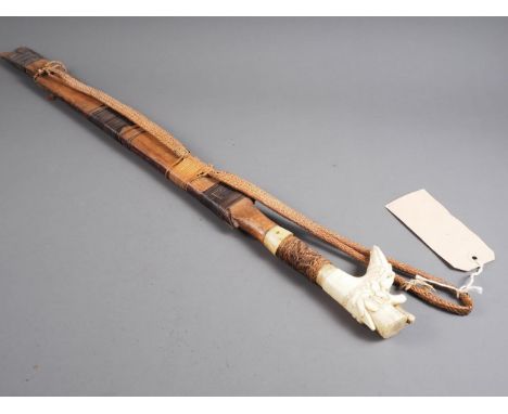 An Indonesian Dayak Mandau sword with paktong? pellets inlaid on the blade and carved bone handle/pommel, and hardwood, bambo