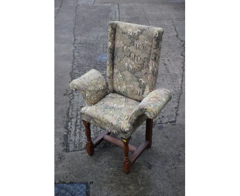 A child's oak armchair of early 17th century design, upholstered in a Jacquard figured tapestry, on turned and stretchered su