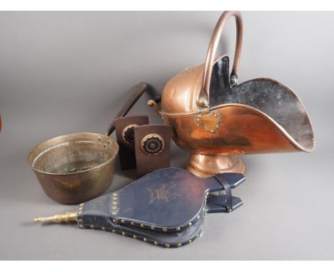 A copper coal helmet, a pair of bellows, a spark guard and a pair of bookends