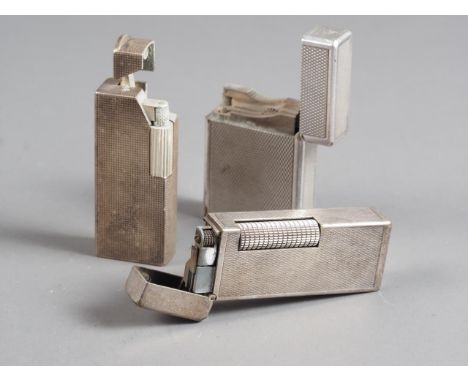 A silver plated Dupont lighter and two similar Dunhill lighters 
