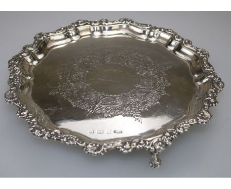 Elkington and Co, an Edwardian silver waiter with scalloped pie crust rim, floral chasing, on three scrolled feet. Birmingham