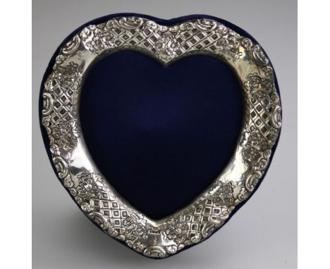 A mid 20th century Britannia silver photograph frame of heart form decorated with floral trellis, on blue plush easel support