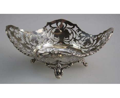 Mappin and Webb, a George V silver bon bon dish, with florally cast rim and pierced navette body on four scrolled shell feet,