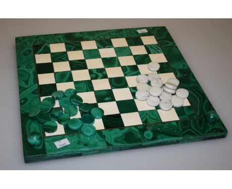 An early 20th century malachite draughts board, a backgammon board (a/f), seventeen green and seventeen white gaming pieces. 