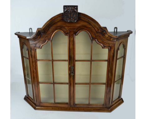 A Dutch bow fronted wall cabinet, the arched top with foliate pediment over two glazed doors, 69cm high