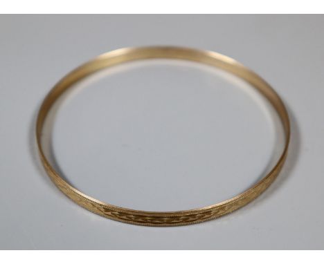9ct gold engraved bangle.  Approx weight 6g.(B.P. 21% + VAT) 