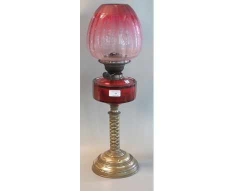 Early 20th century double oil burner lamp having cranberry fluted shade, cranberry glass reservoir on a brass base.(B.P. 21% 