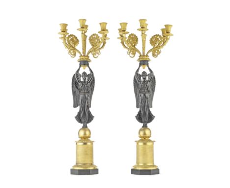 A PAIR OF 19TH CENTURY FRENCH GILT AND PATINATED BRONZE FIGURAL SIX-LIGHT CANDELABRA IN THE EMPIRE TASTEThe five palmette can