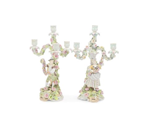 A PAIR OF SCHIERHOLZ FLORAL ENCRUSTED PORCELAIN THREE-BRANCH  CANDELABRALate 19th centuryThe stems mounted with flower seller