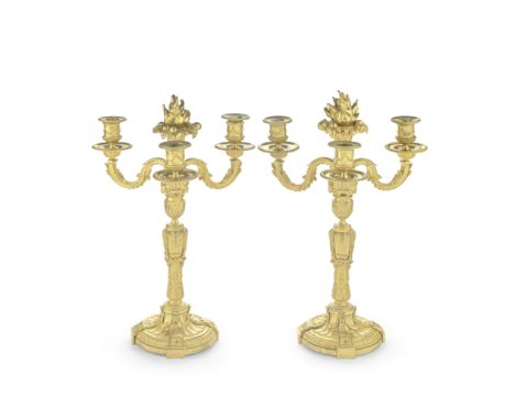 A PAIR OF THREE-LIGHT GILT METAL CANDELABRA19th centuryEach surmounted with a flaming fruit basket clasped in lotus leaves, t