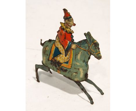 GUNTHERMANN, BAVARIA, EARLY 20th CENTURY EMBOSSED LITHOGRAPH TINPLATE CLOCKWORK TOY CLOWN ON A BUCKING DONKEY, the body in tw