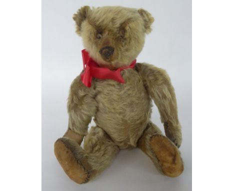AN EARLY 20TH CENTURY GERMAN STEIFF TYPE PALE GOLDEN PLUSH TEDDY BEAR, with replaced pads, protruding muzzle and boot button 