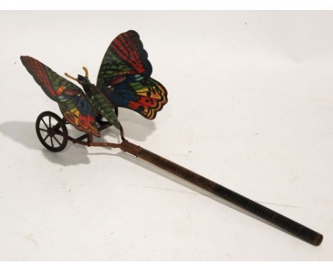 VICTORIAN CHILD'S LITHOGRAPH TIN PLATE PUSH-ALONG FLUTTERING BUTTERFLY CARPET TOY, raised on tin plate frame with tin plate e