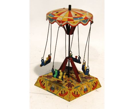 CIRCA 1930s LITHOGRAPH TIN PLATE CLOCKWORK MERRY-GO-ROUND, the four pairs of seated figures suspended from the spinning umbre