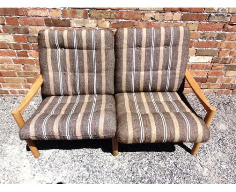 A 1970S BEECH FRAMED TWO SEATER SOFA  with original cloth upholstery, 137cm wide