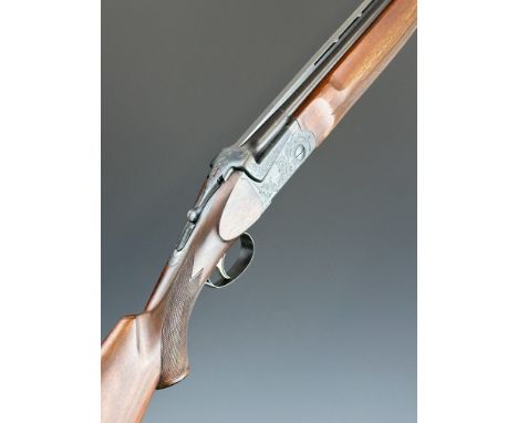 SKB 500 12 bore over and under ejector shotgun with engraved locks, underside, trigger guard and thumb lever, chequered semi-
