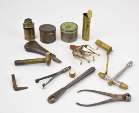 A collection of gun and shooting tools and accessories including T-shaped nipple key with percussion cap storage compartments