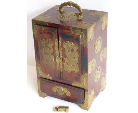 A late 19th century Chinese hardwood and brass-mounted Mahjong cabinet, the swivel-handle modelled as a bat above a central S