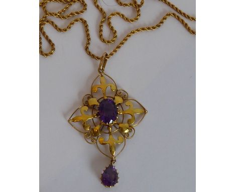 A 9-carat yellow-gold Arts and Crafts-style pendant centrally set with an oval amethyst above a pearl-shaped amethyst dropper