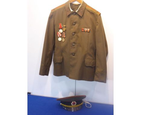 A late 20th century Russian military uniform comprising jacket with medals and medal ribbons, trousers and military cap with 