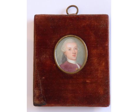 An 18th century oval portrait miniature of a young gentleman in plum-coloured tunic and with white-powdered wig 'en queue' an