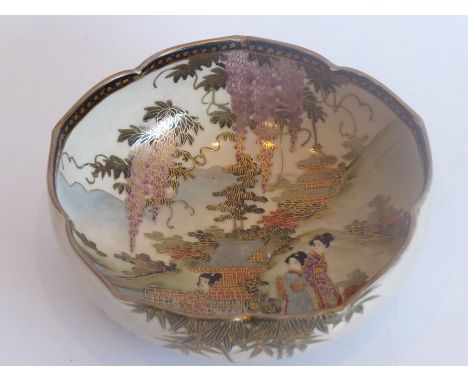 A Japanese Satsuma lotus-shaped pottery dish; very finely gilded and decorated with figures amongst mountainous surroundings 