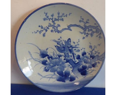 A large late 19th century Japanese porcelain charger hand-decorated in underglaze blue with exotic birds amongst flowers (46c